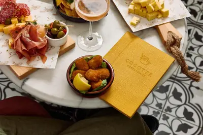 a table with a plate of food and a glass of wine at Van der Valk Hotel Gent in Ghent