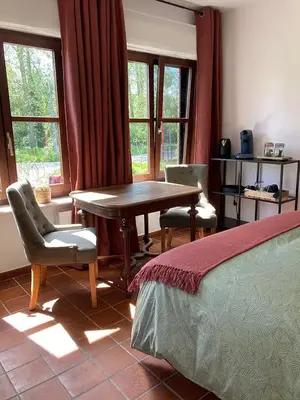 a bedroom with a table and two chairs and a bed at B&B Den Biesthoek in Grimbergen