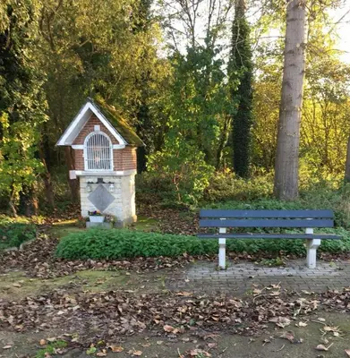a blue bench in a park with a bird house at B&B Den Biesthoek in Grimbergen