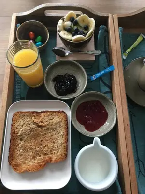 a tray of food with toast and jam and a glass of orange juice at B&B Den Biesthoek in Grimbergen