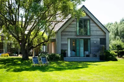 two chairs sitting in the grass in front of a house at B&B Villa Tartine in Puurs