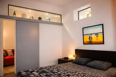 a bedroom with a bed and two mirrors on the wall at Apartments Saint Géry in Brussels