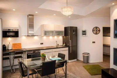 a kitchen with a glass table and black appliances at Apartments Saint Géry in Brussels