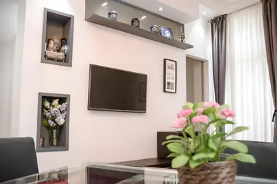 a living room with a tv and flowers on the wall at Apartments Saint Géry in Brussels