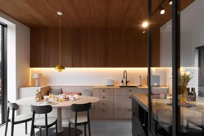 a kitchen with a table and some chairs and a counter at The Pine House B&B in Schoten