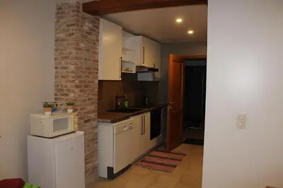 a kitchen with white appliances and a brick wall at Saffels Nest 33 in Lochristi