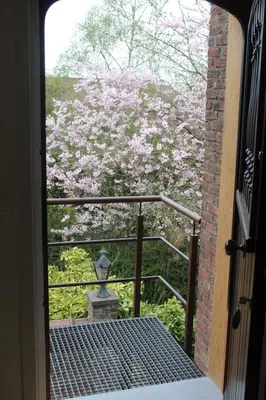 a door leading to a garden with pink flowers at Saffels Nest 33 in Lochristi