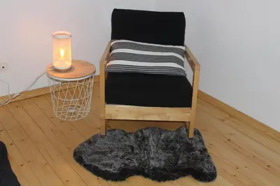 a chair with a blanket and a table with a candle at Saffels Nest 33 in Lochristi