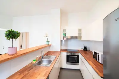a kitchen with white cabinets and a sink at The Antwerp Old Town Lodge in Antwerp