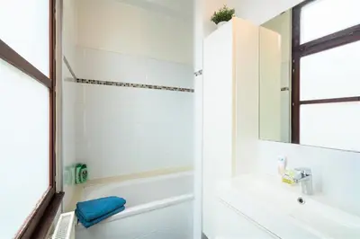 a white bathroom with a tub and a sink at The Antwerp Old Town Lodge in Antwerp