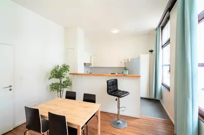 a kitchen and dining room with a table and chairs at The Antwerp Old Town Lodge in Antwerp