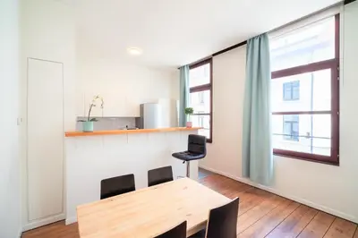 a dining room with a table and chairs and a window at The Antwerp Old Town Lodge in Antwerp