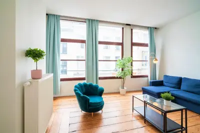 a living room with a blue couch and a table at The Antwerp Old Town Lodge in Antwerp