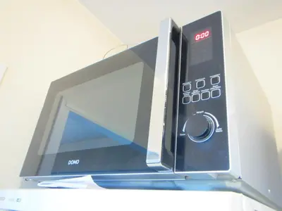a microwave oven sitting on top of a refrigerator at - - - - - Au Sixième Ciel - - - - - in Brussels