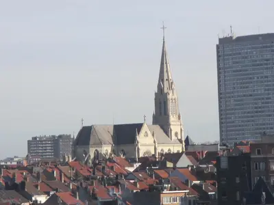 a church with a steeple and roofs of buildings at - - - - - Au Sixième Ciel - - - - - in Brussels