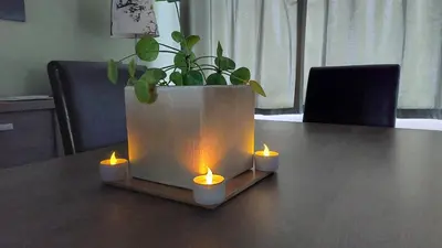 a table with three candles and a potted plant at Vertentenhuis in Hamme