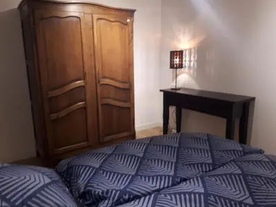 a bedroom with a bed and a wooden cabinet and a desk at Vertentenhuis in Hamme