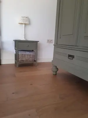 a bedroom with a dresser and a table with a lamp at Vertentenhuis in Hamme