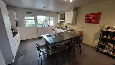 a kitchen with a table and chairs and a sink at Vertentenhuis in Hamme