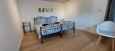 a bedroom with a bed and a chair in a room at Vertentenhuis in Hamme