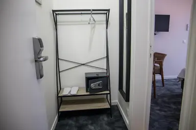 a dressing room with a mirror and a table with a clock at Hotel Guzy Lier Centre in Lier
