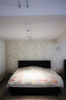 a bedroom with a bed with flowers on the wall at B&B Tempelhof in Ghent