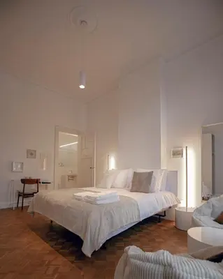a white bedroom with a large bed in a room at ADA in Antwerp