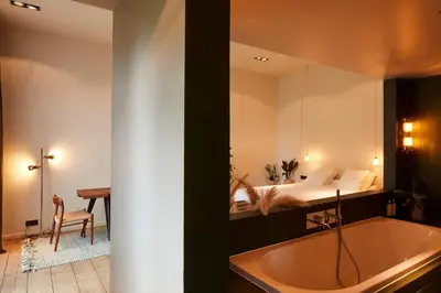 a bathroom with a bath tub and a bedroom at Chambre d'Amis by Alix in Ghent