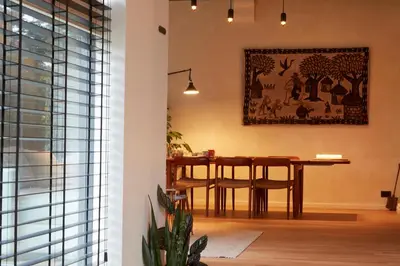 a dining room with a table and a picture on the wall at Chambre d'Amis by Alix in Ghent