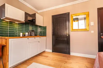 a kitchen with white cabinets and a black door at Luxury Suites Boutique by Rikas Hotels in Antwerp