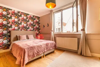 a bedroom with a bed and a floral wall at Luxury Suites Boutique by Rikas Hotels in Antwerp