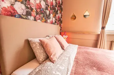 a bedroom with a bed with a floral wall at Luxury Suites Boutique by Rikas Hotels in Antwerp