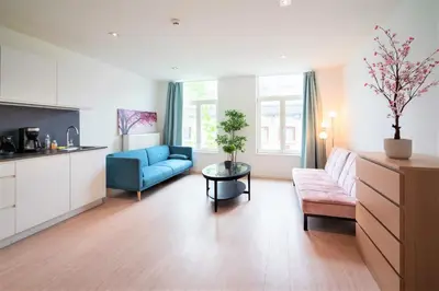 a living room with a blue couch and a table at The Fashion Street Apartments in Antwerp
