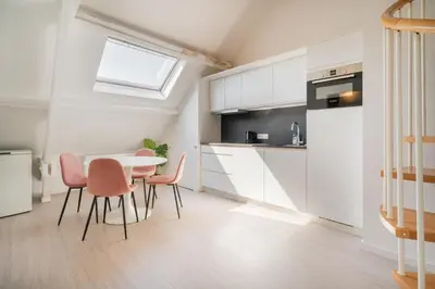 a kitchen with a table and chairs in a room at The Fashion Street Apartments in Antwerp