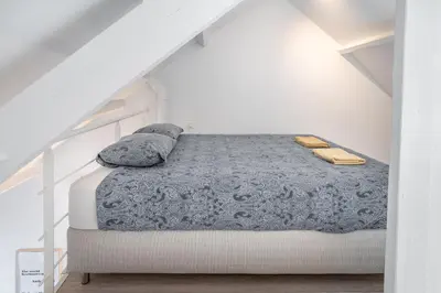 a bedroom with a bed with a blue blanket and pillows at The Fashion Street Apartments in Antwerp