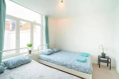 a bedroom with two beds and a window at The Fashion Street Apartments in Antwerp