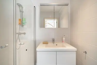 a white bathroom with a sink and a shower at The Fashion Street Apartments in Antwerp