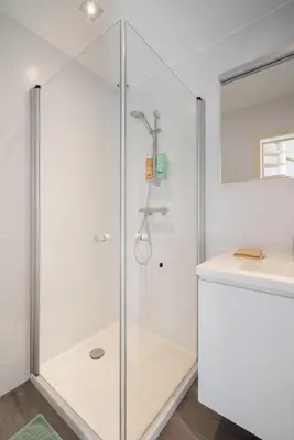 a glass shower stall in a bathroom with a counter at The Fashion Street Apartments in Antwerp