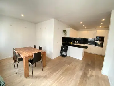 a kitchen and dining room with a wooden table and chairs at The Central Square Residence in Antwerp
