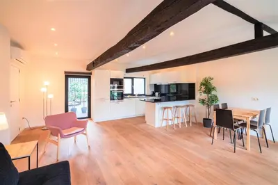 a kitchen and living room with a table and chairs at The Central Square Residence in Antwerp
