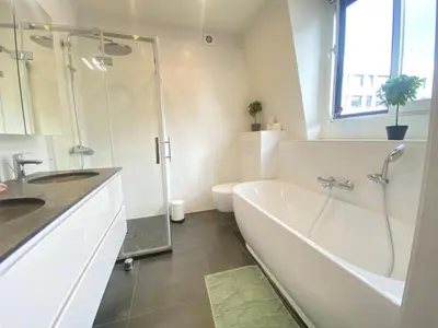 a bathroom with a tub and a shower and a toilet at The Central Square Residence in Antwerp
