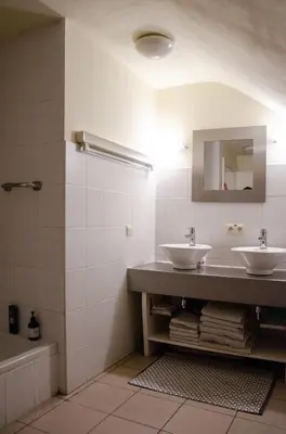 a bathroom with two sinks and a mirror at Hageland Vakantieverblijf in Holsbeek