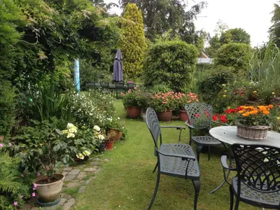 a garden with a table and chairs and flowers at B&B Carisma in Lochristi