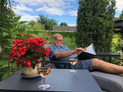 an older man sitting at a table with two glasses of wine at B&B Carisma in Lochristi