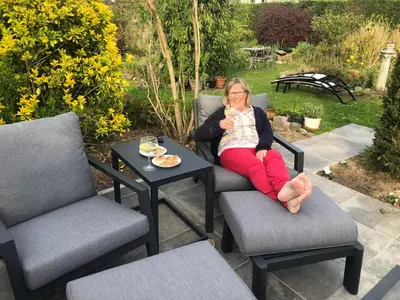 a woman sitting in a chair eating a cup of coffee at B&B Carisma in Lochristi