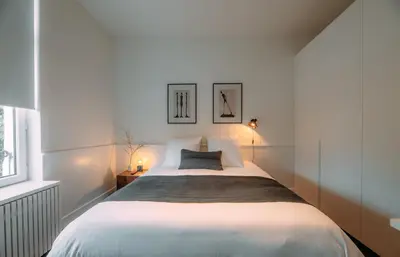 a bedroom with a white bed with two pictures on the wall at Sud d'Anvers in Antwerp