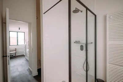 a shower with a glass door in a bathroom at Sud d'Anvers in Antwerp