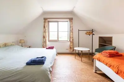 a bedroom with two beds and a window at Vakantiehuis Wandelen en fietsen in de Kalkense Meersen dichtbij Gent in Laarne