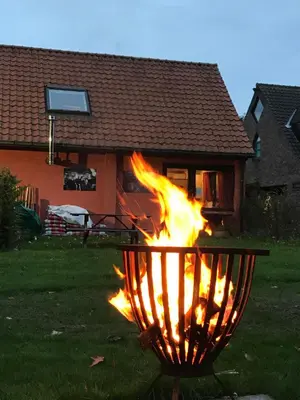 a fire in a grill in front of a house at Vakantiehuis Wandelen en fietsen in de Kalkense Meersen dichtbij Gent in Laarne