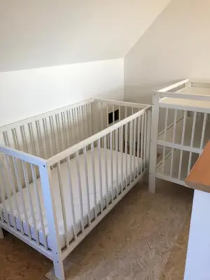 two white cribs in a room with a wall at Vakantiehuis Wandelen en fietsen in de Kalkense Meersen dichtbij Gent in Laarne